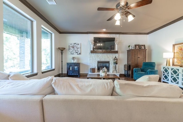 living room with crown molding, ceiling fan, and a fireplace