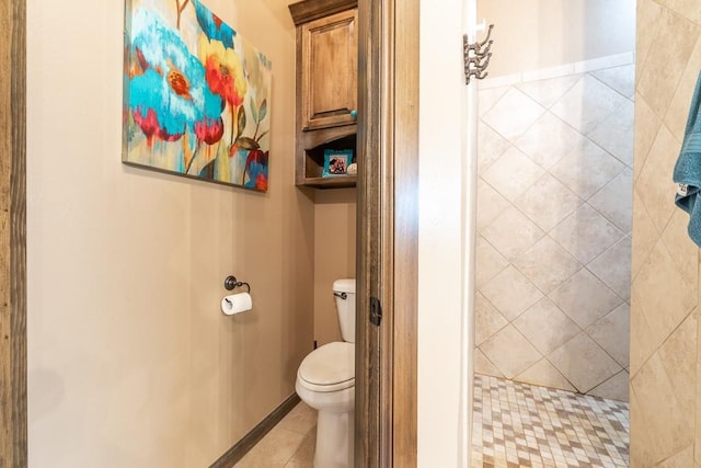 bathroom with tile patterned floors, toilet, and a tile shower