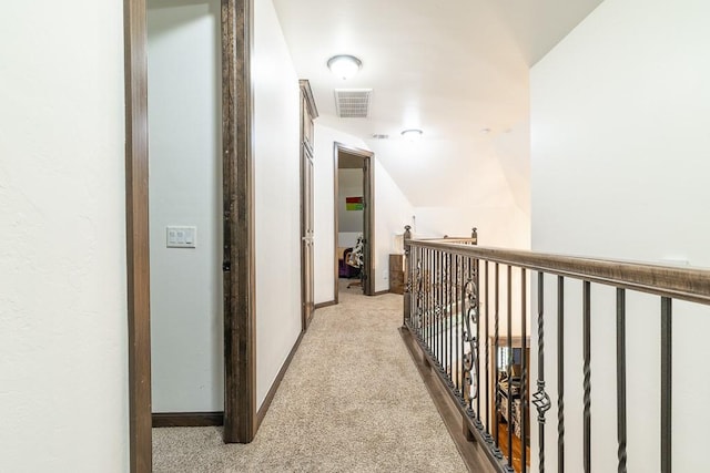 hallway with lofted ceiling and light carpet