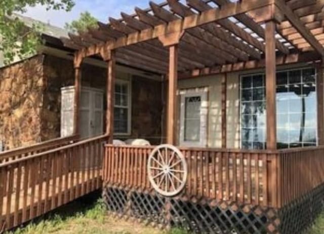 view of home's exterior featuring a wooden deck and a pergola