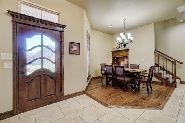 tiled entryway with an inviting chandelier