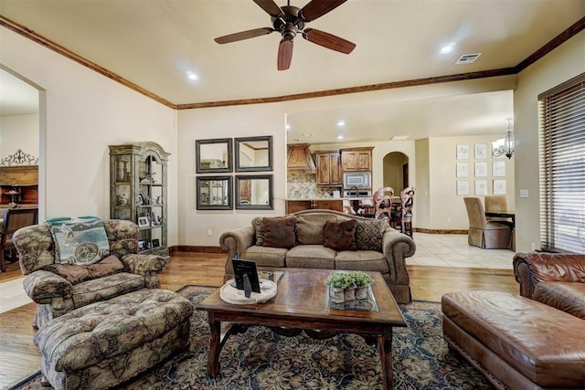 living room with ornamental molding, ceiling fan, and light hardwood / wood-style floors