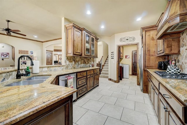 kitchen featuring custom exhaust hood, sink, backsplash, and stainless steel appliances