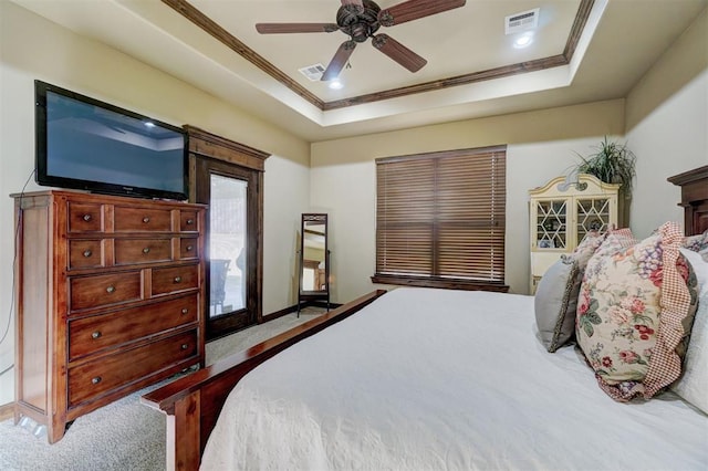 bedroom with crown molding, carpet flooring, a tray ceiling, and ceiling fan