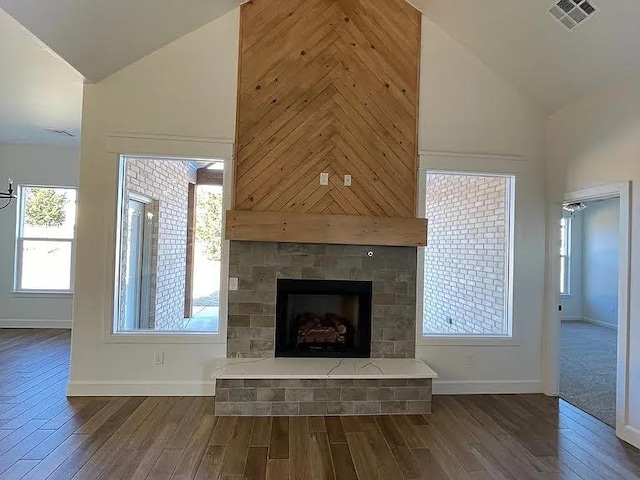 unfurnished living room featuring dark wood-type flooring and high vaulted ceiling