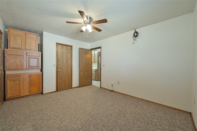 unfurnished bedroom featuring ceiling fan, light colored carpet, a textured ceiling, and a closet