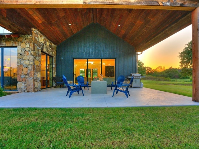 patio terrace at dusk with a grill and a lawn