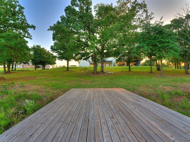 deck at dusk featuring a yard