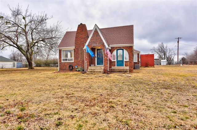 view of front of property with central AC and a front lawn