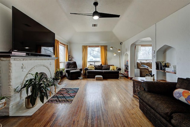 living room featuring a fireplace, a wealth of natural light, light hardwood / wood-style flooring, and ceiling fan