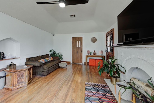 living room featuring a raised ceiling, hardwood / wood-style floors, and ceiling fan