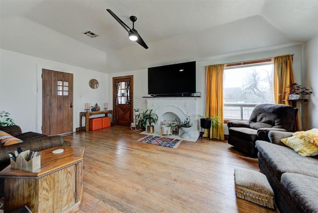 living room with ceiling fan, wood-type flooring, a tray ceiling, and a wealth of natural light