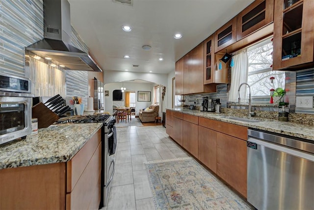 kitchen featuring light stone counters, appliances with stainless steel finishes, extractor fan, and sink