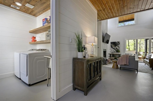 washroom featuring a high ceiling, wooden ceiling, and washing machine and clothes dryer