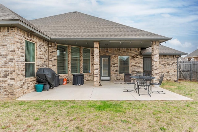 back of property with a yard and a patio area