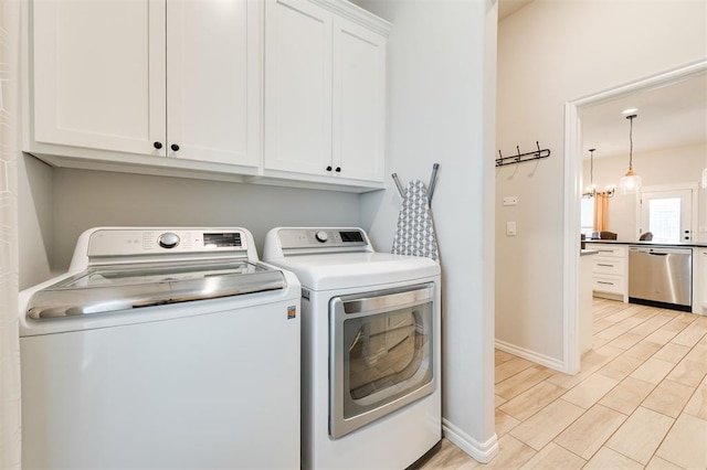 clothes washing area featuring cabinets and washer and dryer