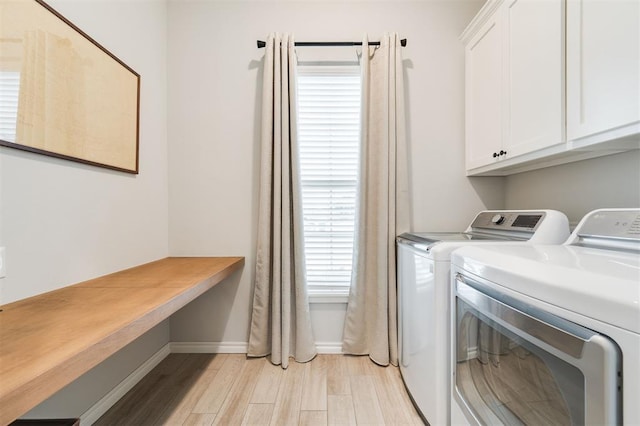 washroom with independent washer and dryer, cabinets, and light hardwood / wood-style floors