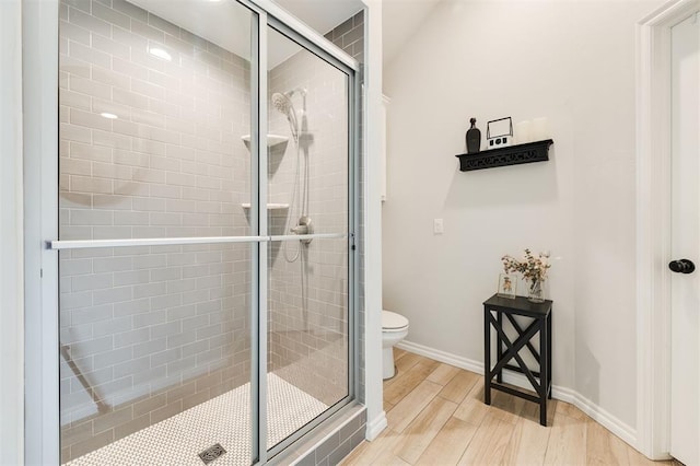 bathroom with a shower with door, wood-type flooring, and toilet