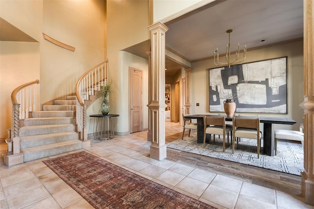 dining area featuring crown molding, decorative columns, a high ceiling, and light tile patterned flooring