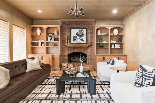 living room featuring ornamental molding, a chandelier, a fireplace, and light hardwood / wood-style flooring