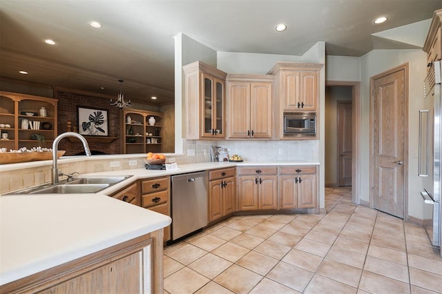 kitchen with sink, light tile patterned floors, stainless steel appliances, decorative backsplash, and kitchen peninsula