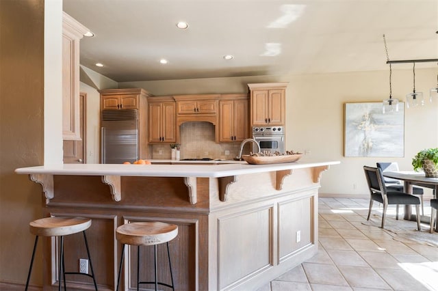 kitchen with a kitchen island, appliances with stainless steel finishes, backsplash, and a kitchen bar