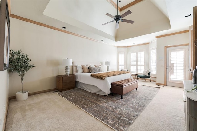 carpeted bedroom featuring ceiling fan, ornamental molding, a tray ceiling, and access to exterior