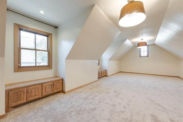 additional living space with light colored carpet and vaulted ceiling