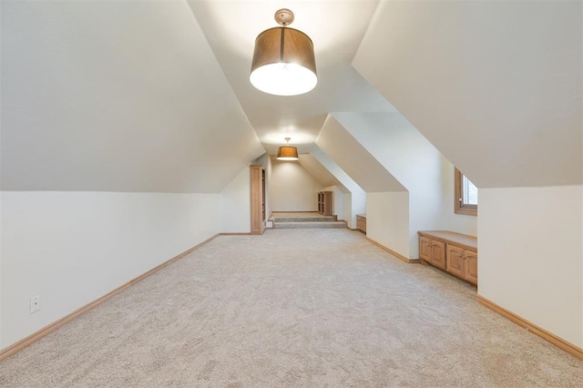 additional living space with light colored carpet and lofted ceiling