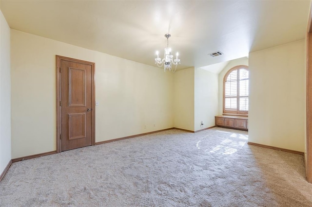 carpeted empty room featuring a notable chandelier