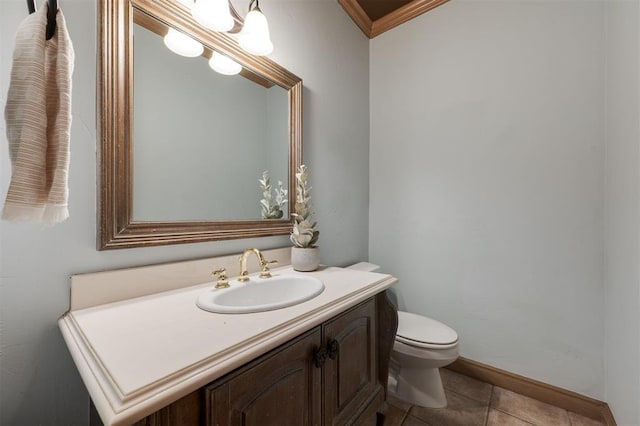 bathroom with ornamental molding, vanity, toilet, and tile patterned flooring