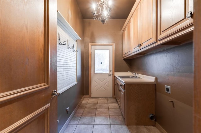 laundry room with sink, cabinets, a chandelier, light tile patterned floors, and electric dryer hookup