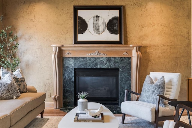 sitting room with a premium fireplace and wood finished floors