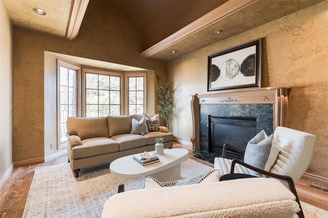 living area featuring a premium fireplace, wood finished floors, and baseboards