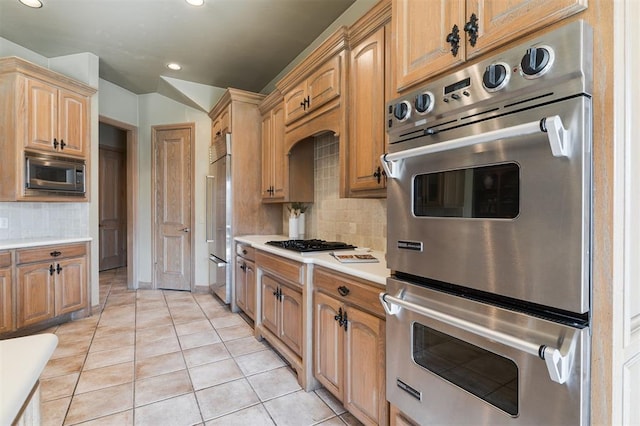 kitchen featuring appliances with stainless steel finishes, light tile patterned flooring, light countertops, backsplash, and recessed lighting