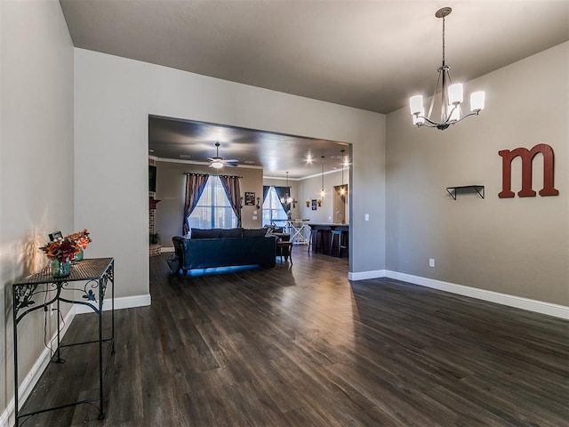 dining area featuring a fireplace, ceiling fan with notable chandelier, and dark wood-type flooring