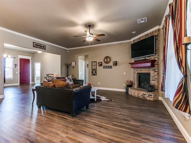 living room featuring a fireplace, ornamental molding, dark hardwood / wood-style floors, and ceiling fan