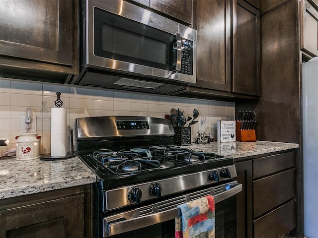 kitchen featuring stainless steel appliances, dark brown cabinetry, and decorative backsplash