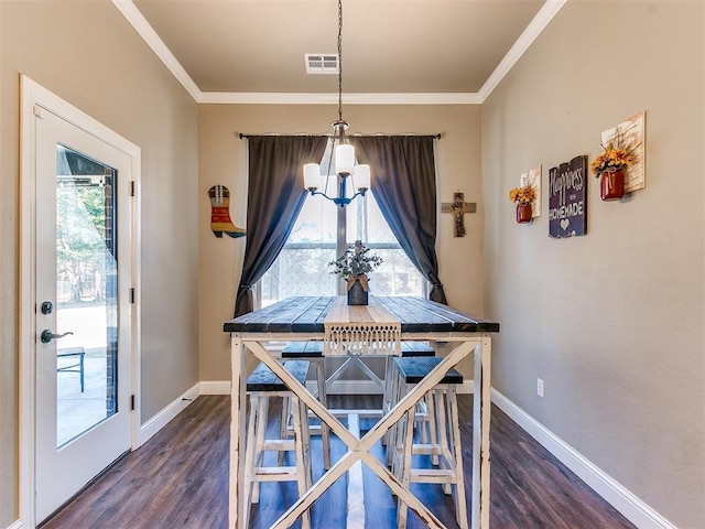 dining space featuring dark hardwood / wood-style flooring, crown molding, and an inviting chandelier