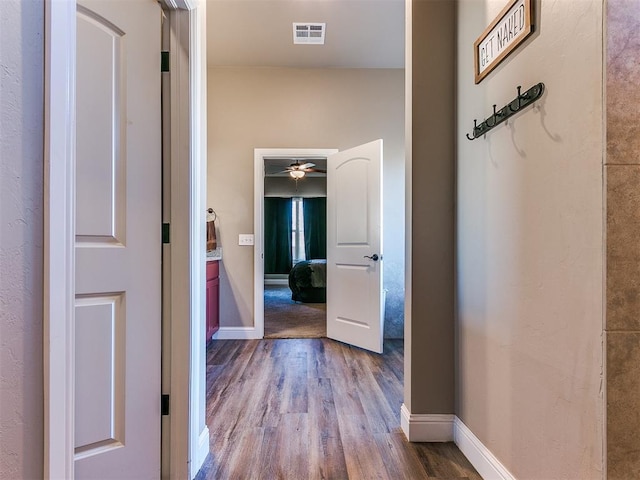 corridor with hardwood / wood-style flooring