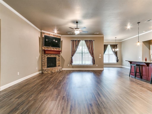 9015 Tall Oaks Dr, Guthrie, OK 73044 - unfurnished living room featuring a fireplace, ceiling fan, dark wood-style flooring, baseboards, and crown molding