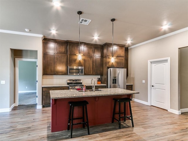 9015 Tall Oaks Dr, Guthrie, OK 73044 - kitchen with stainless steel appliances, a sink, ornamental molding, tasteful backsplash, and a kitchen bar