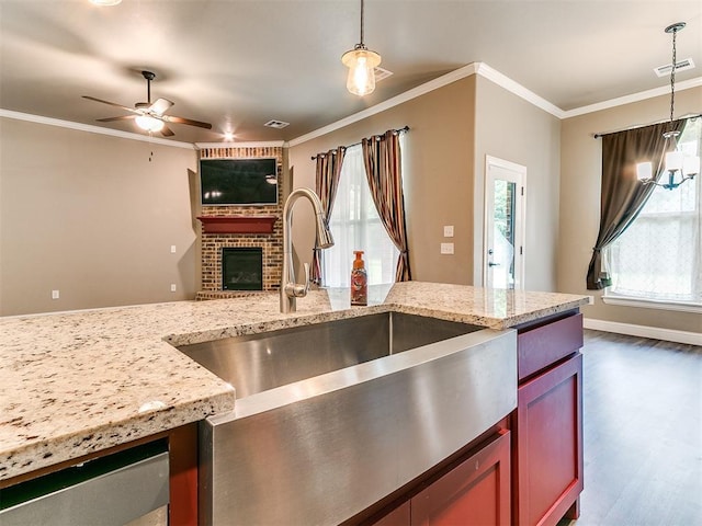 9015 Tall Oaks Dr, Guthrie, OK 73044 - kitchen featuring a sink, ceiling fan, dark wood finished floors, a brick fireplace, and crown molding