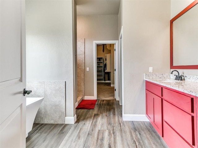 9015 Tall Oaks Dr, Guthrie, OK 73044 - full bathroom featuring wood finished floors, a spacious closet, vanity, a freestanding bath, and baseboards