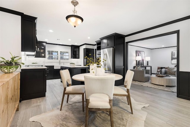 dining room with crown molding and light wood-type flooring