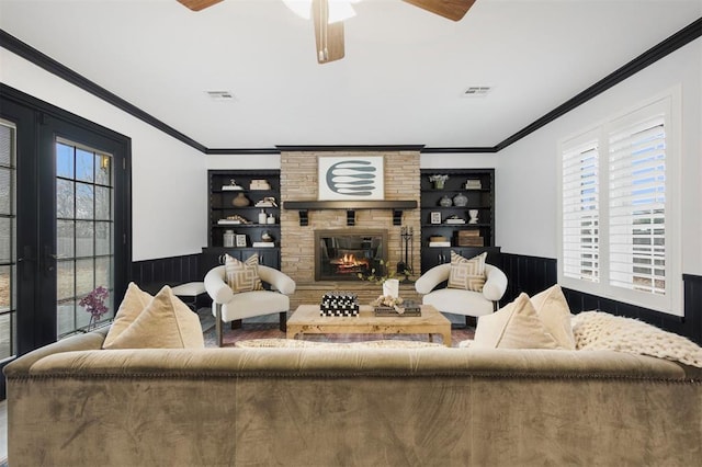 living room featuring a brick fireplace, crown molding, and ceiling fan