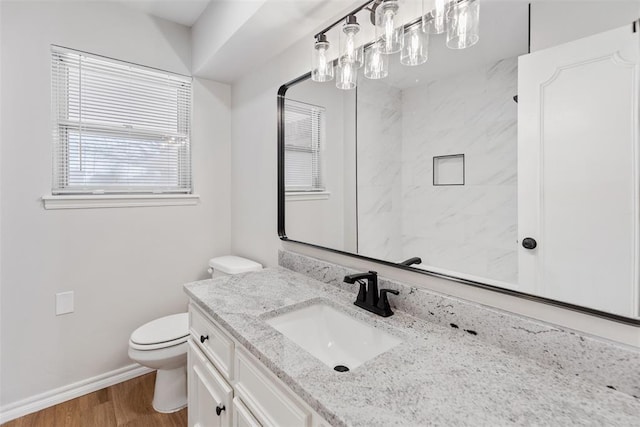 bathroom featuring vanity, hardwood / wood-style flooring, toilet, and a tile shower