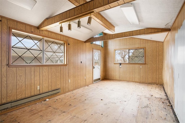 unfurnished room with a baseboard heating unit, wooden walls, and lofted ceiling with beams