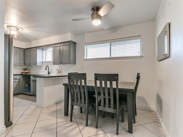 dining space featuring sink, light tile patterned floors, and ceiling fan