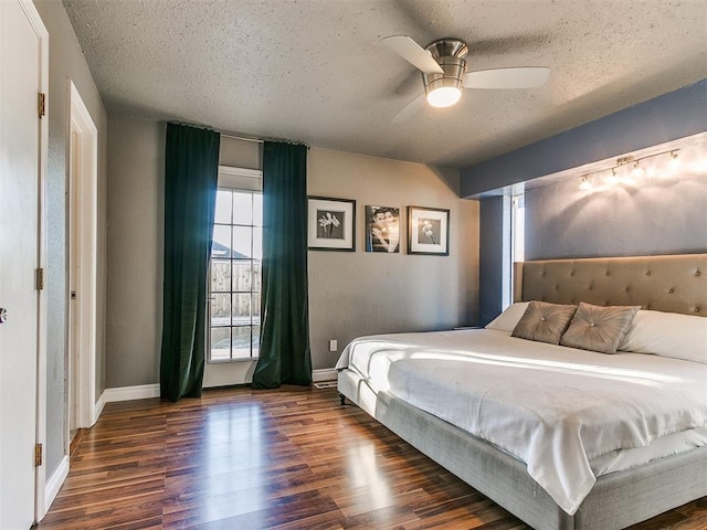 bedroom with dark wood-type flooring, ceiling fan, and a textured ceiling